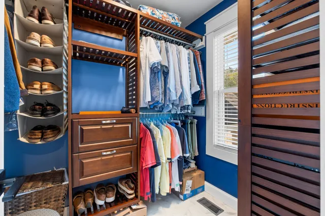 a view of walk in closet with clothes and shoes