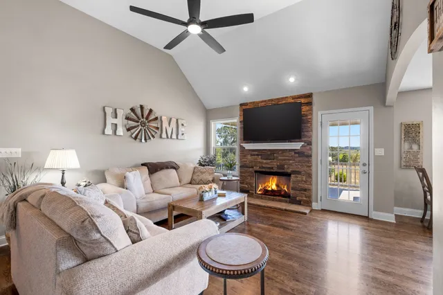 a living room with furniture a fireplace and a flat screen tv
