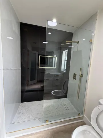a bathroom with a toilet a sink and mirror