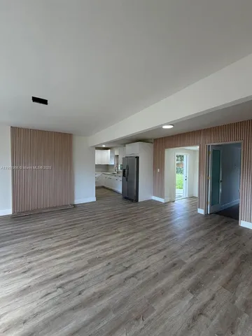 a view of empty room with wooden floor and window