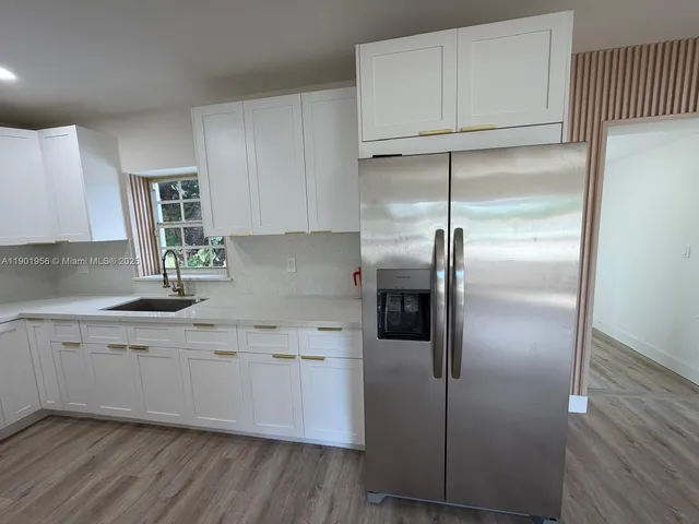 a kitchen with kitchen island a counter top space cabinets and stainless steel appliances