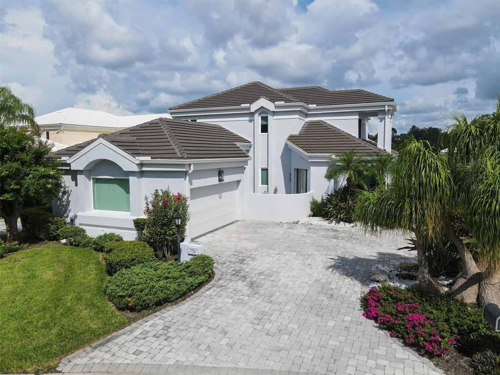 7716 Club Lane Sarasota, FL 34238 - Photo 11 of 68 a front view of a house with a yard and potted plants