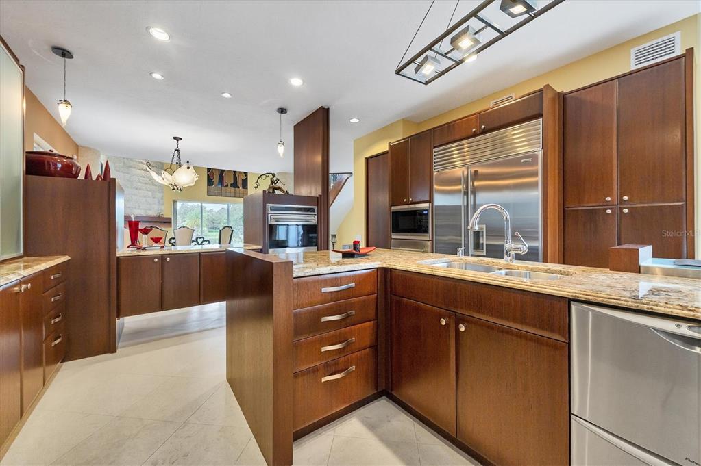 7716 Club Lane Sarasota, FL 34238 - Photo 30 of 68 a kitchen with stainless steel appliances kitchen island granite countertop a refrigerator and a sink