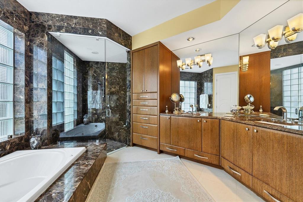 7716 Club Lane Sarasota, FL 34238 - Photo 38 of 68 a large bathroom with a double vanity sink a large mirror and a bathtub