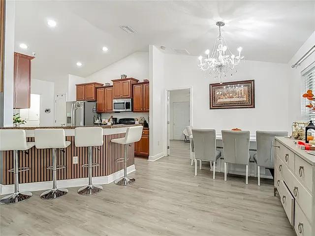 a kitchen with stainless steel appliances kitchen island granite countertop a sink and a refrigerator