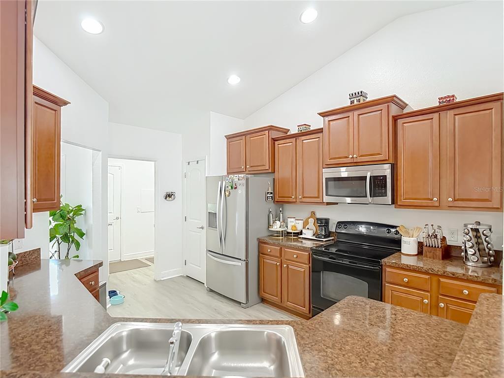 13108 Oneida Street Spring Hill, FL 34609 - Photo 16 of 62 a kitchen that has a sink cabinets counter space and stainless steel appliances