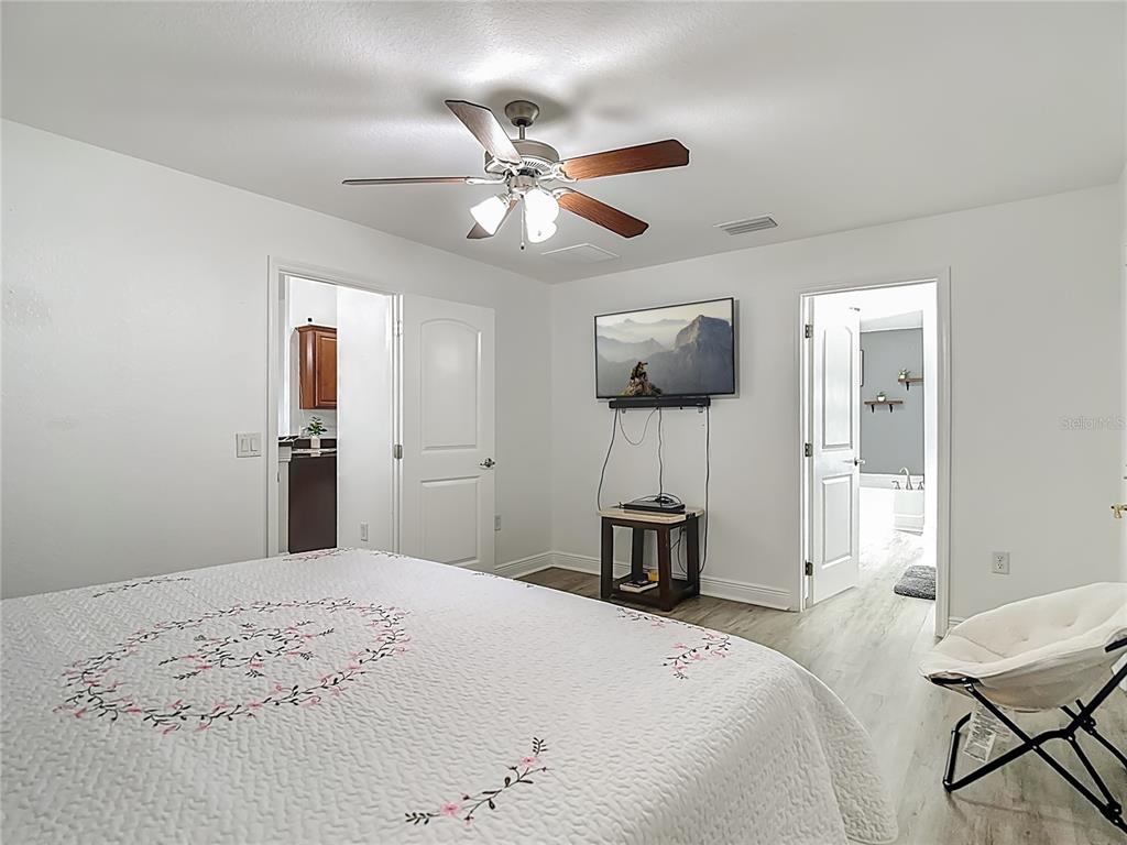 13108 Oneida Street Spring Hill, FL 34609 - Photo 27 of 62 a bedroom with a bed and a chandelier