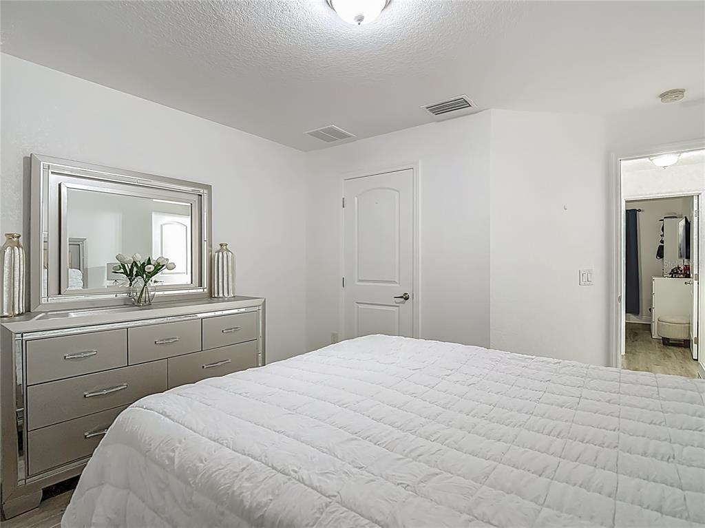 13108 Oneida Street Spring Hill, FL 34609 - Photo 42 of 62 a bedroom with a bed and a mirror