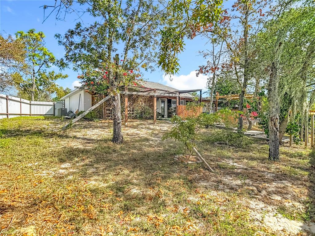 13108 Oneida Street Spring Hill, FL 34609 - Photo 59 of 62 a view of a house with backyard and tree