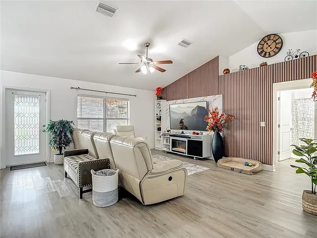 a living room with furniture and view of kitchen