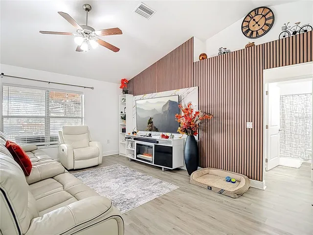 a living room with furniture kitchen view and a potted plant
