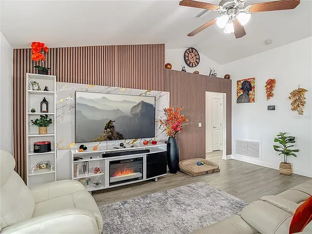 a dining room with chandelier and wooden floor