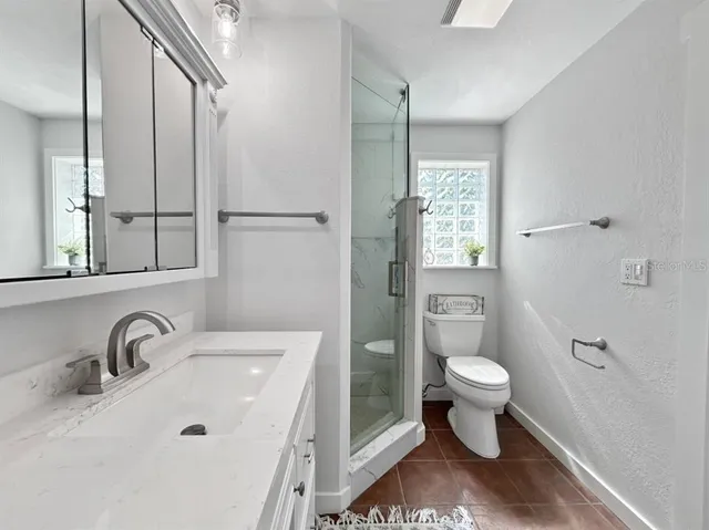 a bathroom with a sink toilet a mirror and shower