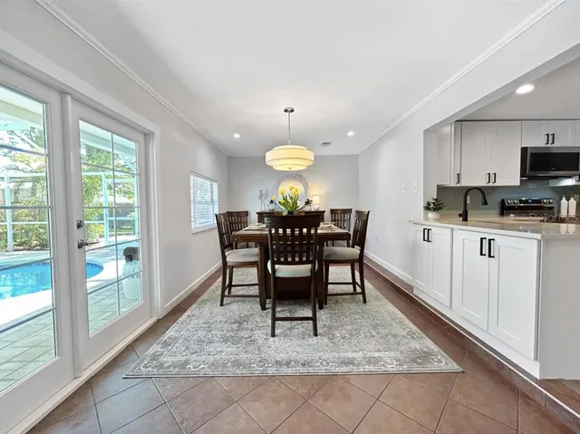 a kitchen with stainless steel appliances granite countertop a table and chairs in it