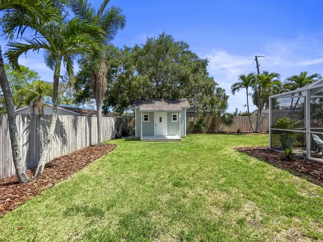 a view of a house with backyard and a tree