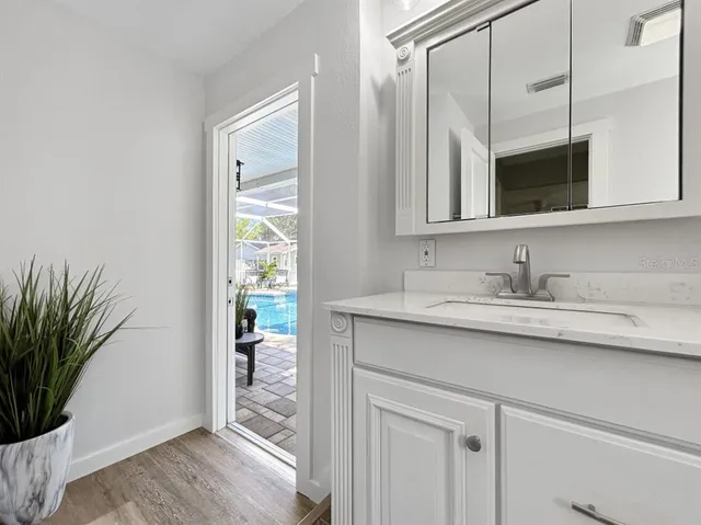 a bathroom with a granite countertop sink a mirror and a shower