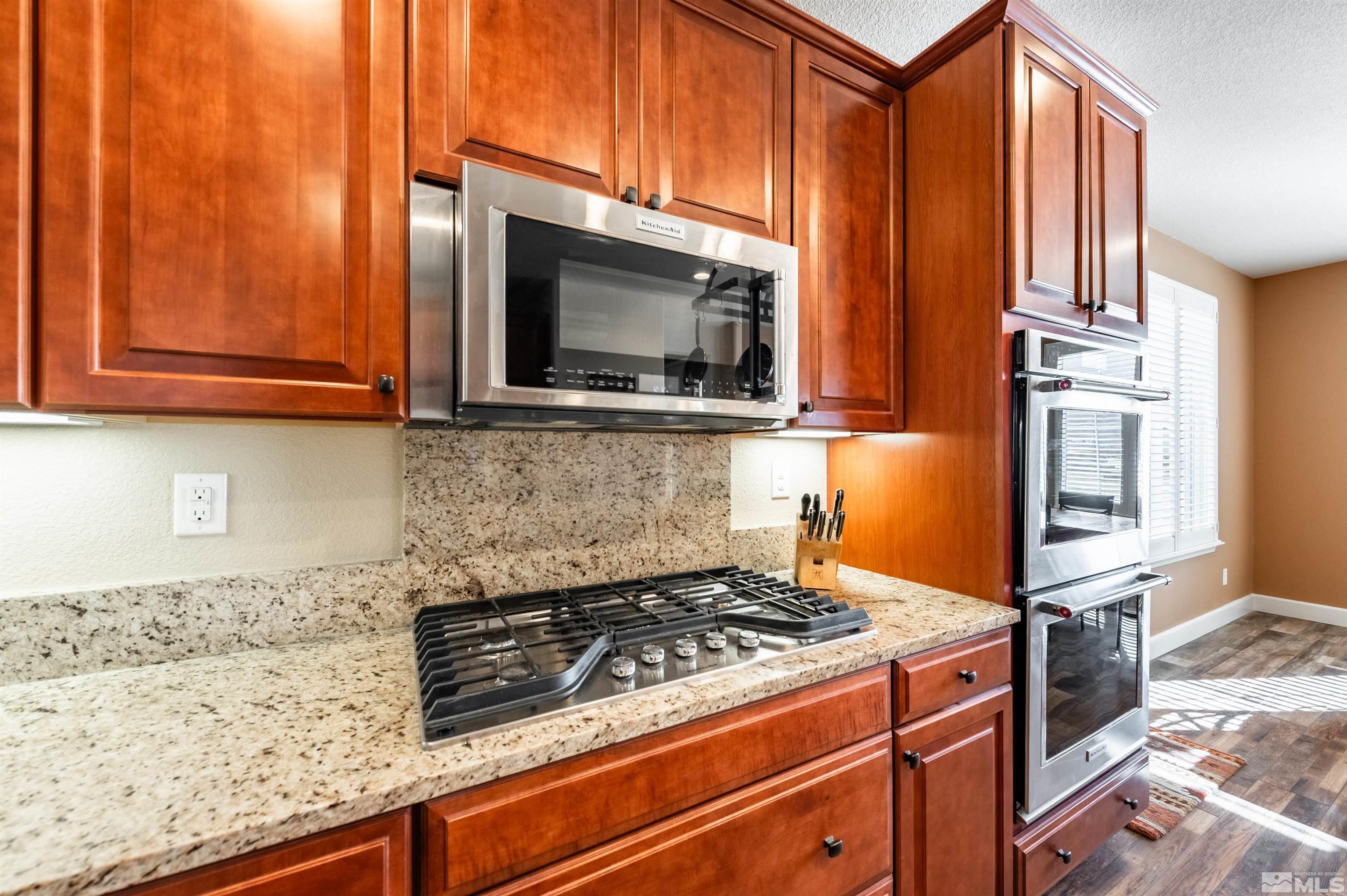 990 Broderick Trail Reno, NV 89523 - Photo 12 of 38 a kitchen with granite countertop a stove top oven microwave and cabinets