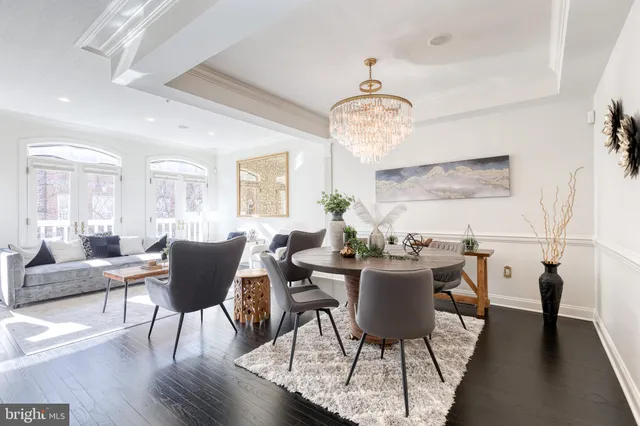 a view of a dining room with furniture a chandelier and wooden floor