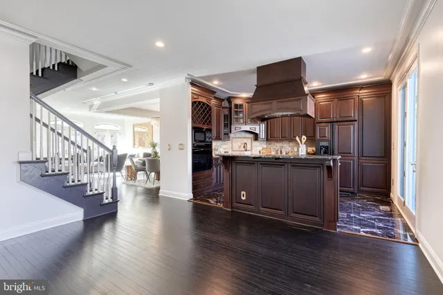 a kitchen with a refrigerator and wooden floor