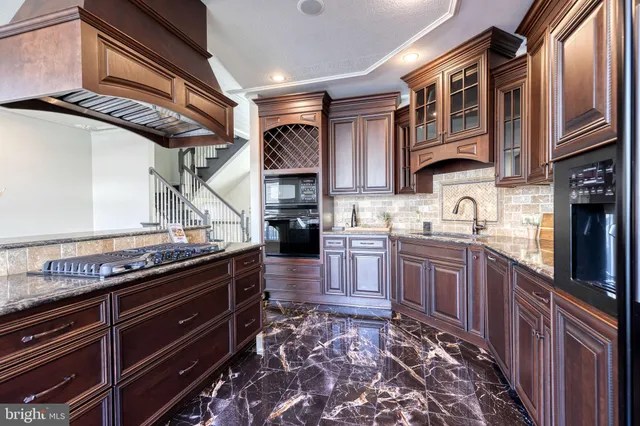 a kitchen with stainless steel appliances granite countertop a stove sink and cabinets