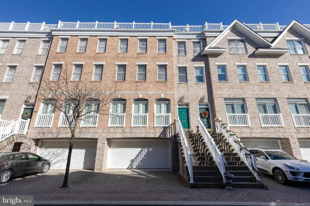 a front view of a building with a couple of cars parked in front of it