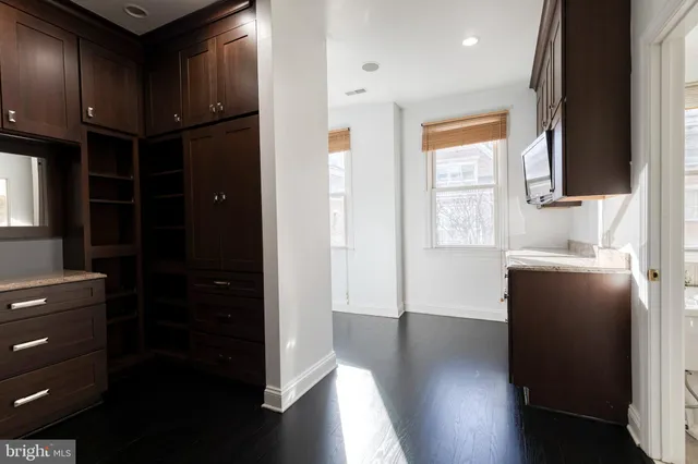 a room with wooden floor pool table and windows