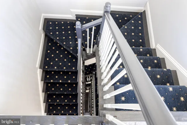a view of a patio with table and chairs potted plants and floor to ceiling window
