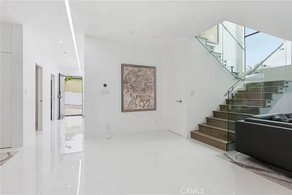 a view of a hallway with wooden floor and a kitchen