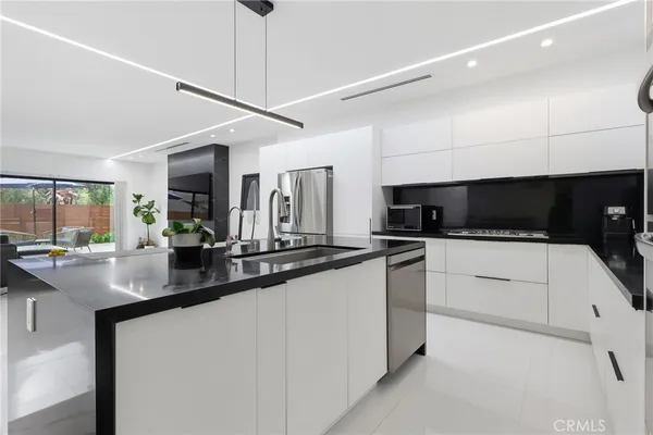 a kitchen with stainless steel appliances granite countertop a sink and a stove