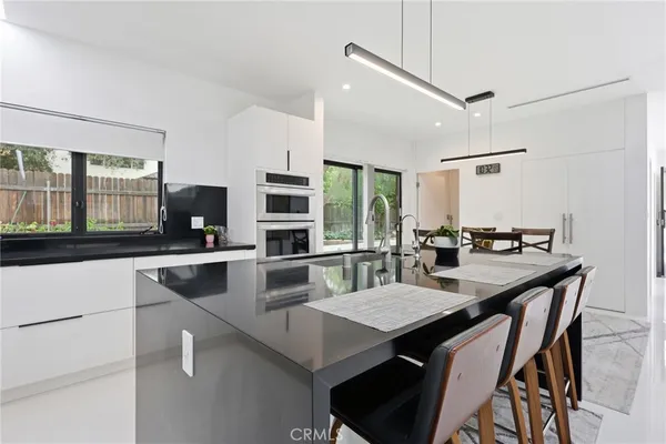 a kitchen with stainless steel appliances a dining table chairs and granite counter tops