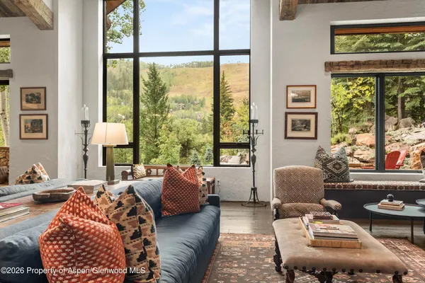 a living room with furniture a bookshelf and a large window