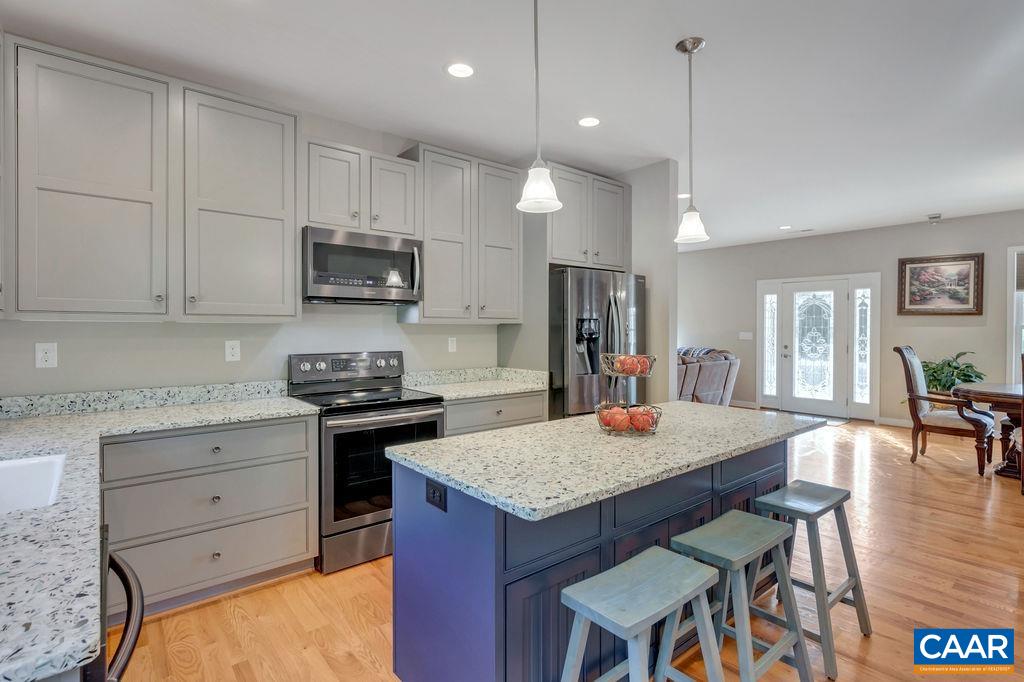 1275 Poplar Spring Road Scottsville, VA 24590 - Photo 3 of 51 a kitchen with a stove a refrigerator and a dining table with wooden floor