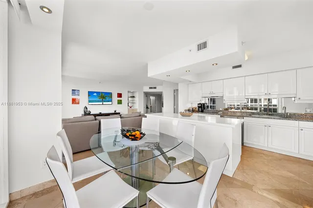 a kitchen with stainless steel appliances granite countertop a dining table and chairs