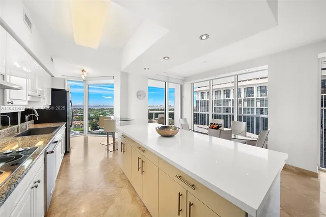 a large kitchen with stainless steel appliances a lot of counter space and a wooden floor