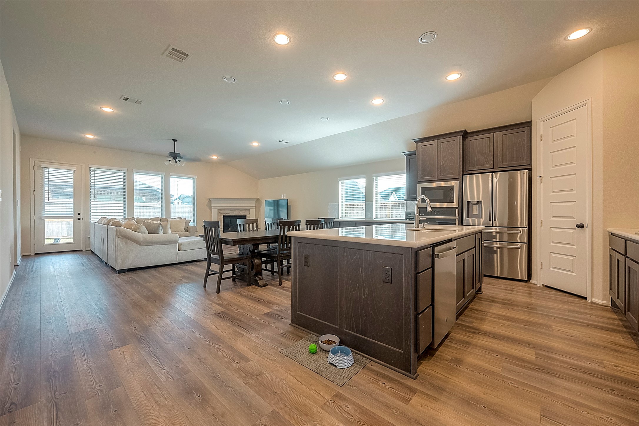 4602 Ana Ridge Lane Fulshear, TX 77441 - Photo 13 of 42 a kitchen with stainless steel appliances kitchen island granite countertop wooden floors and a view of living room