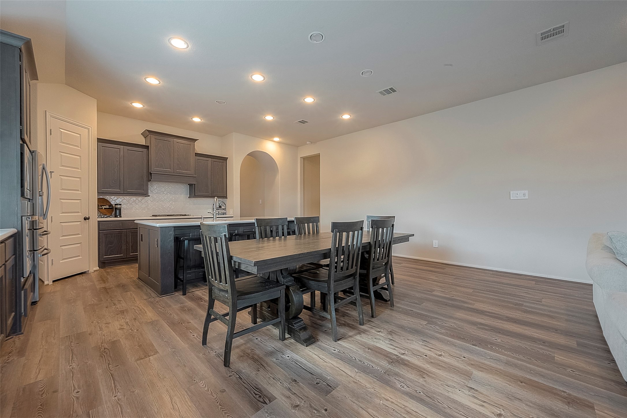 4602 Ana Ridge Lane Fulshear, TX 77441 - Photo 19 of 42 a kitchen with stainless steel appliances kitchen island granite countertop a table chairs sink and cabinets