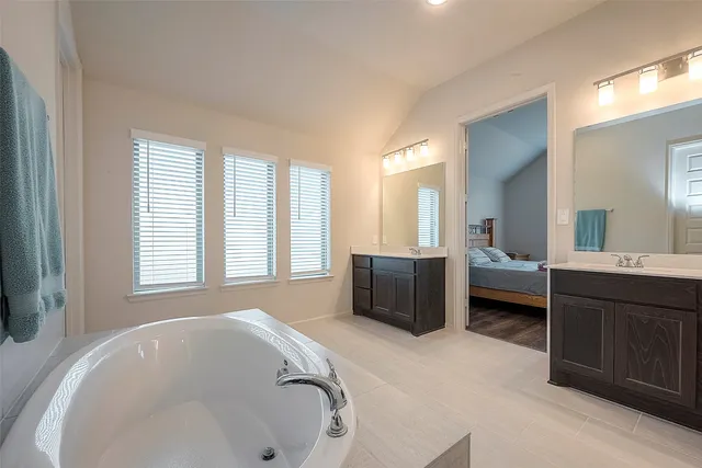 a en suite bathroom with a tub sink and mirror