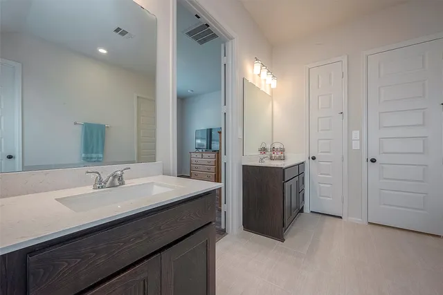 a bathroom with a double vanity sink a mirror and a bathtub