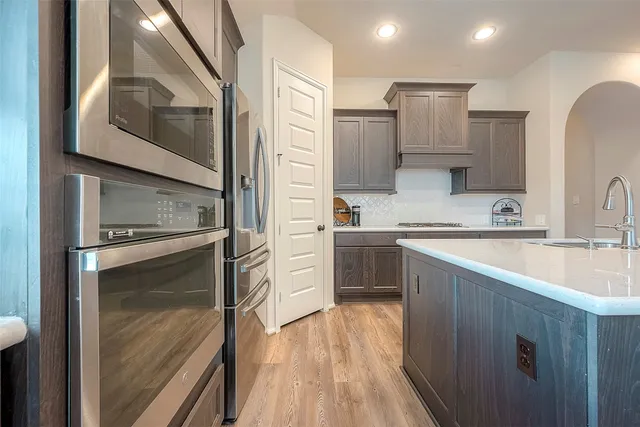 a kitchen with a refrigerator sink and cabinets