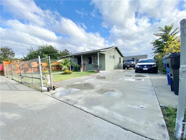 a view of a house with a yard and potted plants