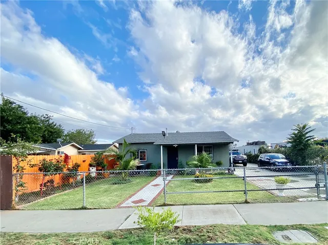 a view of house with a big yard and potted plants