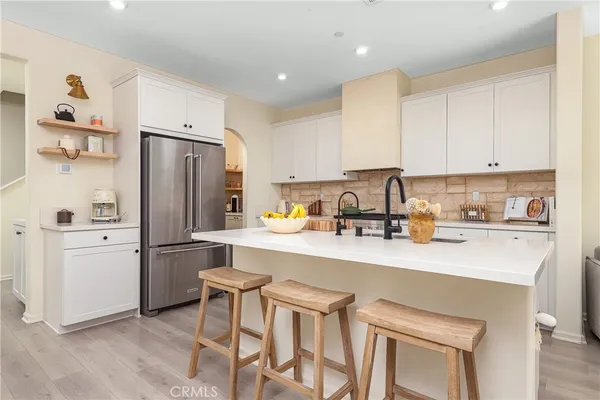 a kitchen with a refrigerator a stove a sink and cabinets