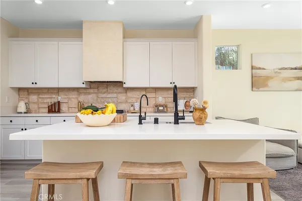 a kitchen with a sink a stove and white cabinets