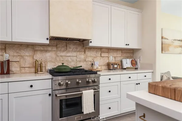 a kitchen with white cabinets and appliances