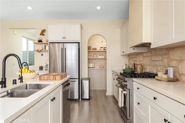a kitchen with stainless steel appliances a sink a stove and cabinets