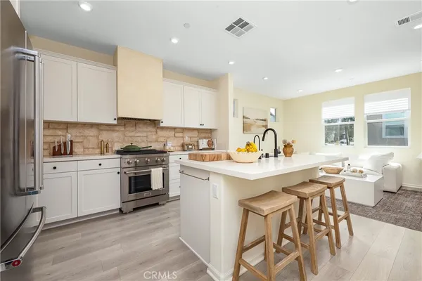 a kitchen with a stove cabinets and chairs