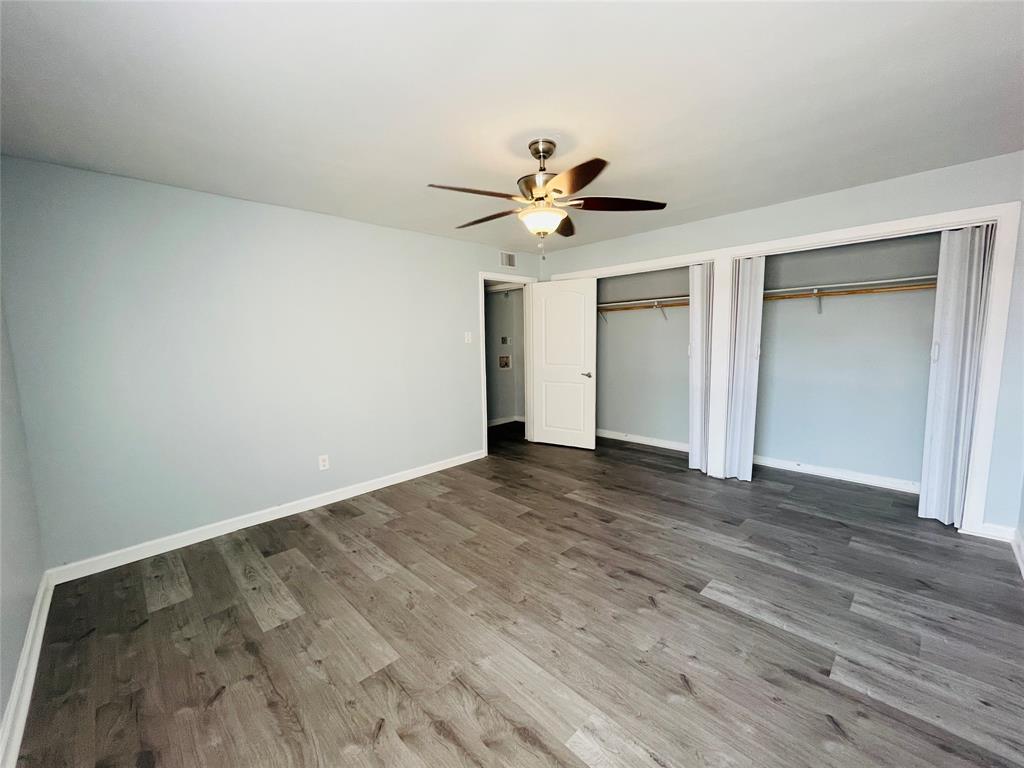 3121 Park Lane, Unit 1105 Dallas, TX 75220 - Photo 15 of 19 Unfurnished bedroom featuring multiple closets, wood finished floors, and ceiling fan