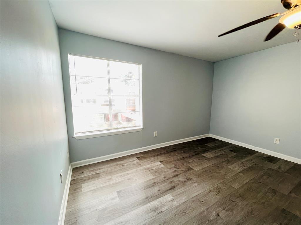 3121 Park Lane, Unit 1105 Dallas, TX 75220 - Photo 16 of 19 Spare room with healthy amount of natural light, a ceiling fan, and dark wood-type flooring