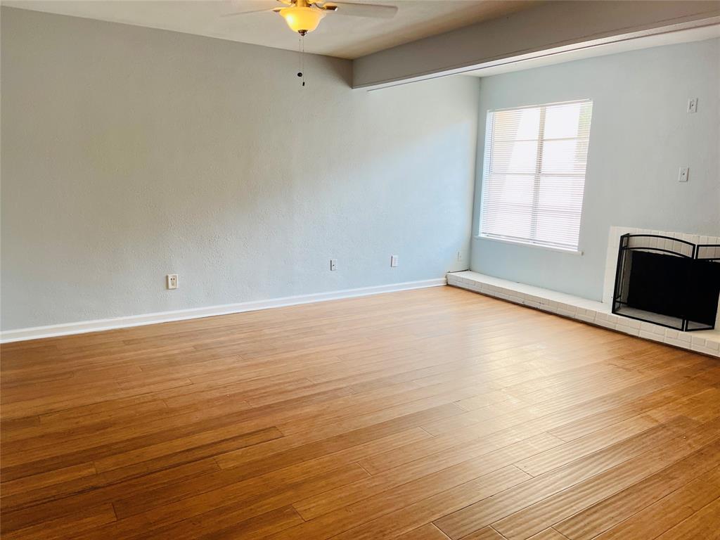 3121 Park Lane, Unit 1105 Dallas, TX 75220 - Photo 6 of 19 Unfurnished living room featuring a ceiling fan and light wood-type flooring