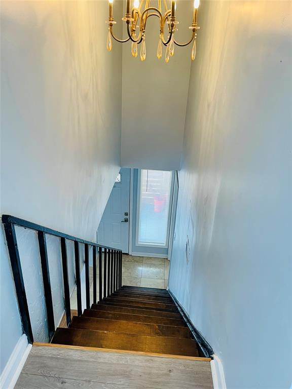 3121 Park Lane, Unit 1105 Dallas, TX 75220 - Photo 8 of 19 Stairway with hardwood / wood-style flooring and a chandelier